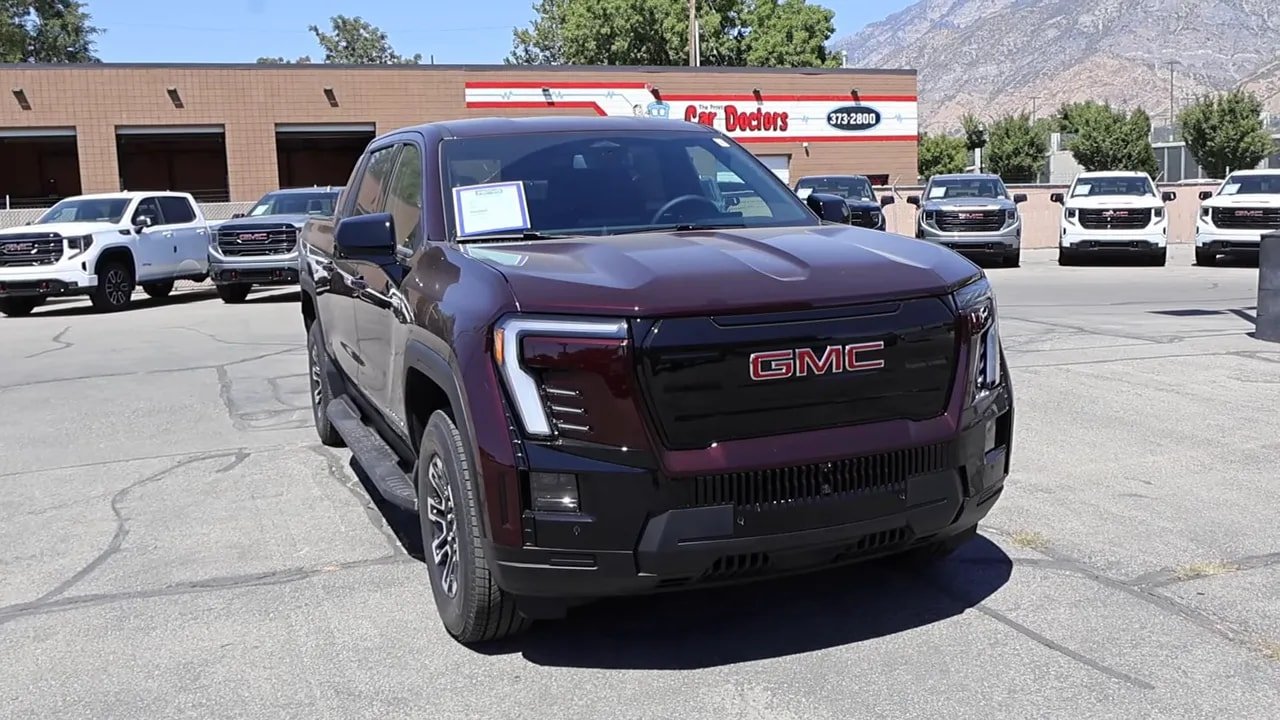 2026 GMC Sierra EV Elevation Standard Range front three-quarter view at a dealership, clear view of grille and headlights
