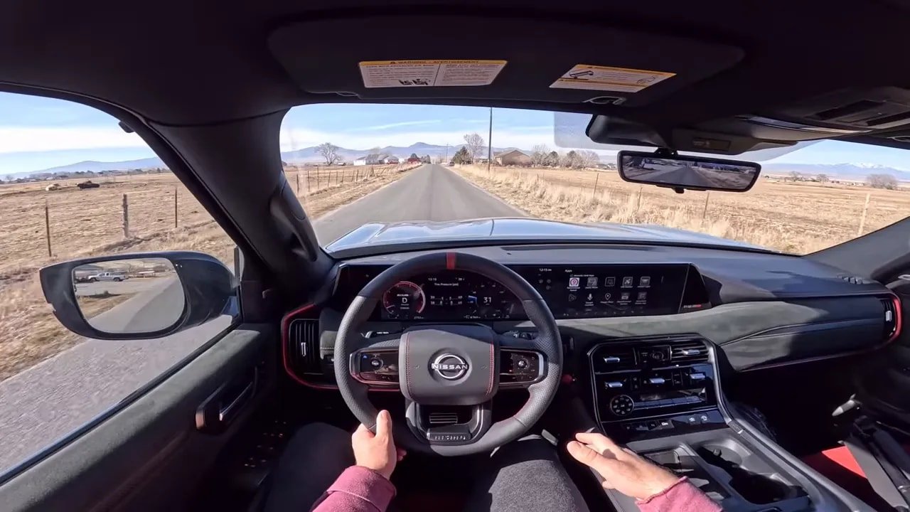 Centered cockpit view of Nissan Armada Nismo with steering wheel, digital display and road ahead