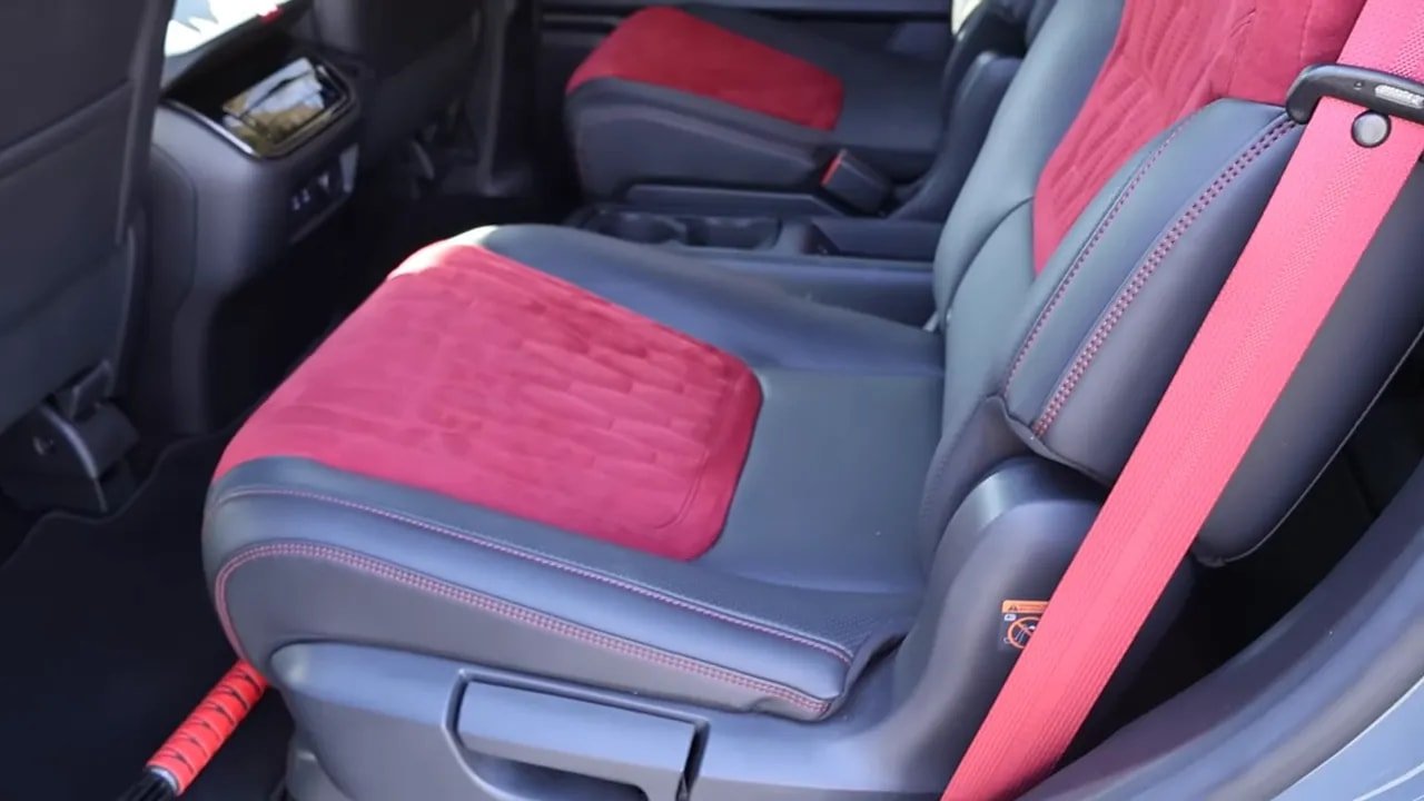 Second-row captain seat with red suede insert and red seatbelt in Armada Nismo