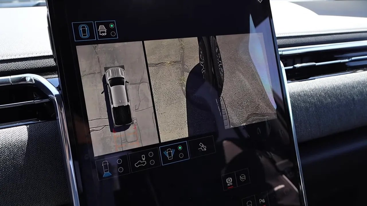 Center touchscreen showing 360-degree top-down camera and curbside wheel view in GMC Sierra EV