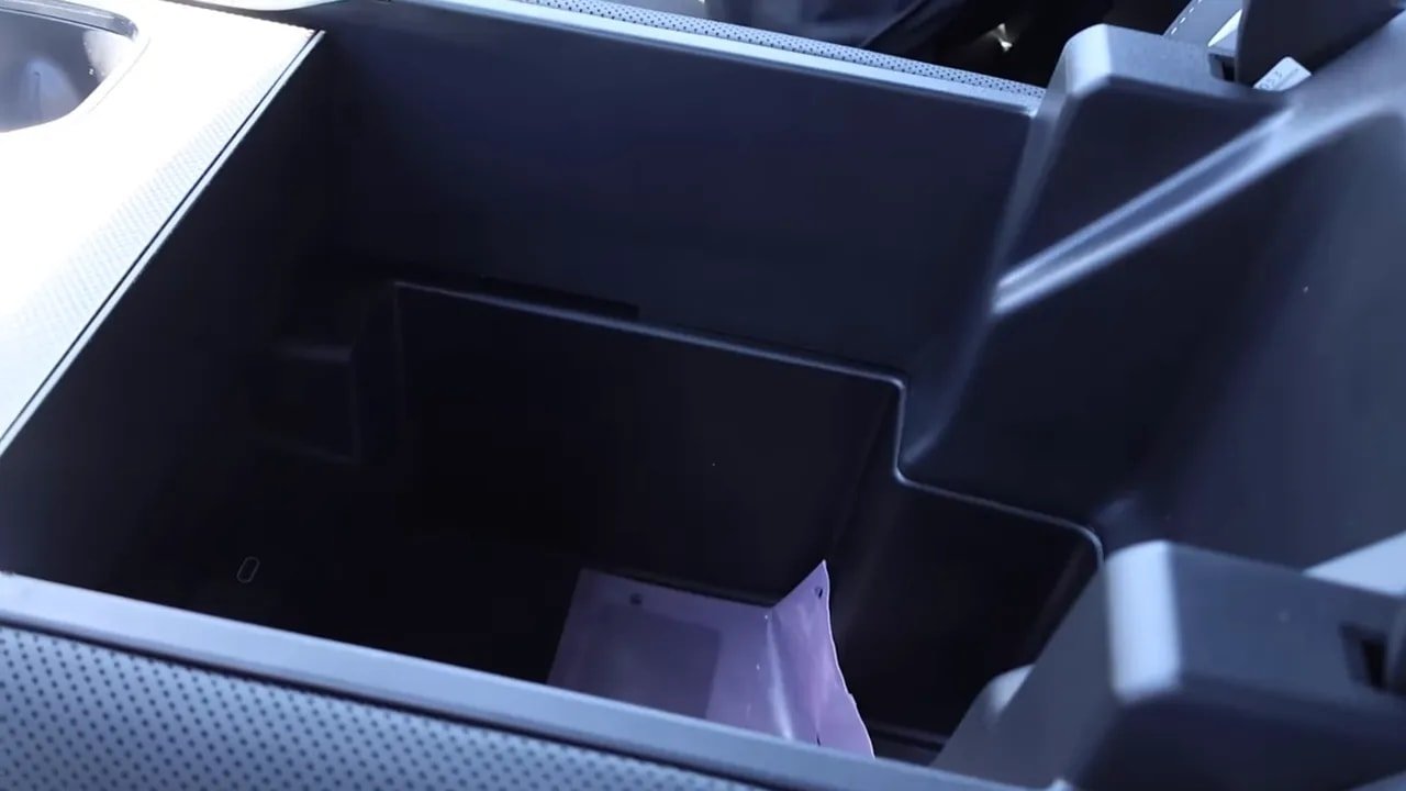 Open deep center console storage bin in the GMC Sierra EV showing spacious interior for large items